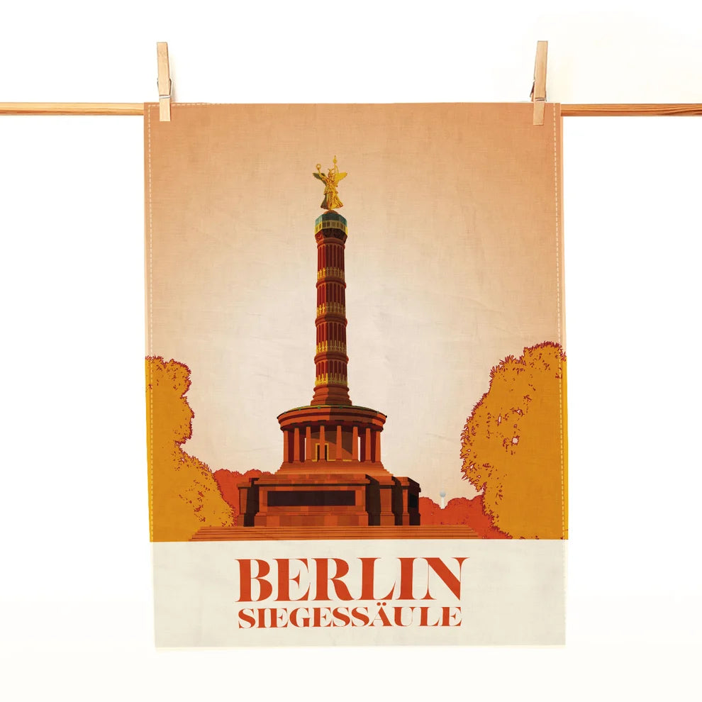 Geschirrtuch mit Motiv der Berliner Siegessäule und rotem Schriftzug, an einer Holzleiste befestigt.