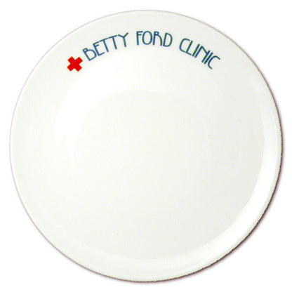 Weißer runder Teller mit Betty-Ford-Clinic-Schriftzug und rotem Kreuz, von oben